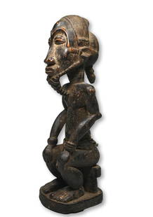 A Baule Male Effigy Ex Dr Jackson Collection: A carved wooden male effigy with stylized beard and coiffure, hands to his knees seated on a stool. Baule peoples, Ivory Coast, West Africa. The sculpture measures 14 x 4 x 5 inches. Provenance: Ex