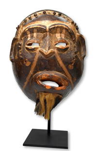 A Bakongo Mask Ex Sotheby's, Ex Hersey Collection: A Carved wooden mask with inset wooden studs, painted linear designs and a animal hide beard attached to the chin. Glossy surface patina and well worn edges. Bakongo peoples, DRC/ Congo, Africa. The m