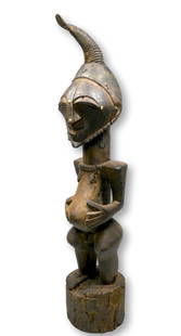 A Songye Nkisi Community Power Figure Ex Gavigan Collection: A tall boldly carved wooden Nkisi effigy or power figure, with wonderful strong face, animal horn, classic form and obvious wear and field use, areas of staining where animal hides once adorned the sc