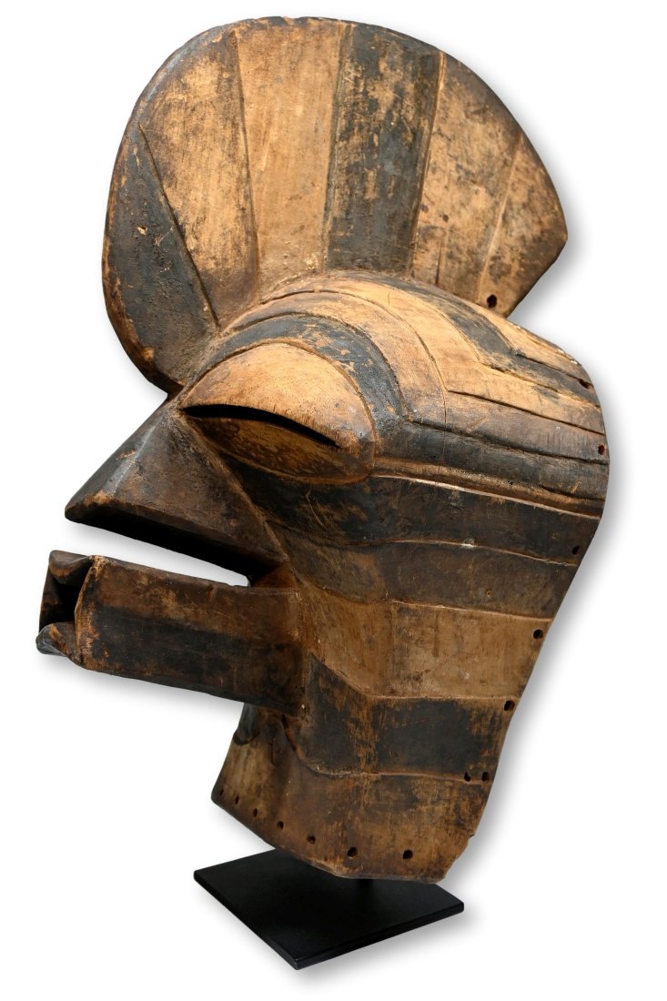A Songye Kifwebe Society Dance mask: A carved wooden ceremonial mask with strong classic features, stylized protruding mouth and nose, raised central crest and linear designs accented with organic pigments. Songye peoples, DRC. Congo, ce