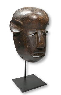 A Fine Old Makonde Ceremonial Mask: A wonderfully stylized carved wooden ceremonial mask with well weathered and well handled surface. Makonde peoples, Mozambique, Africa. The mask measures 12 x 9 inches, 18 inches tall on professional