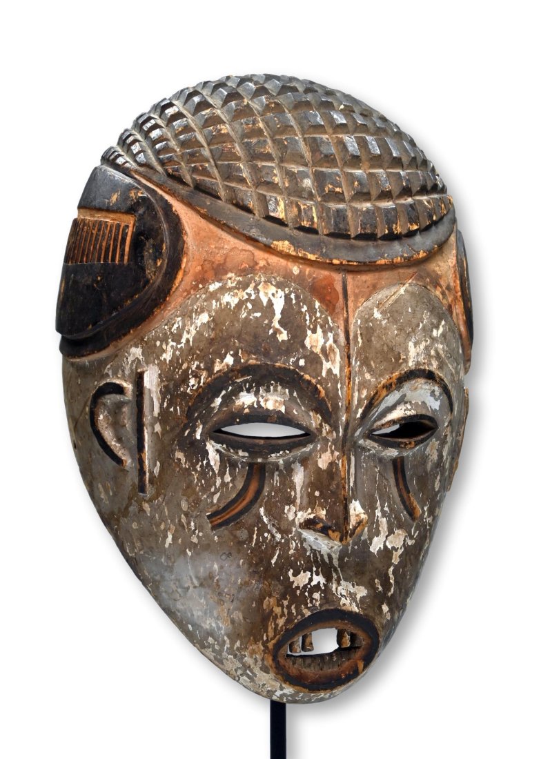 Ibo African Mask: A carved wooden ceremonial Dance mask with incised and raised geometric designs and accented with mineral pigments, wooden teeth. Ibo peoples, Nigeria, West Africa. The mask measures 15 x 9.5 inches. 