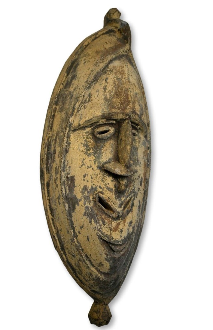 A Ramu Ceremonial Mask Collected 1983: A Carved wooden house mask, Possibly Keram or Ramu; Madang province , Papua new Guinea.The mask of classical flat-style, with long nose and smiling mouth, the surface encrusted, likely Mid-century, th