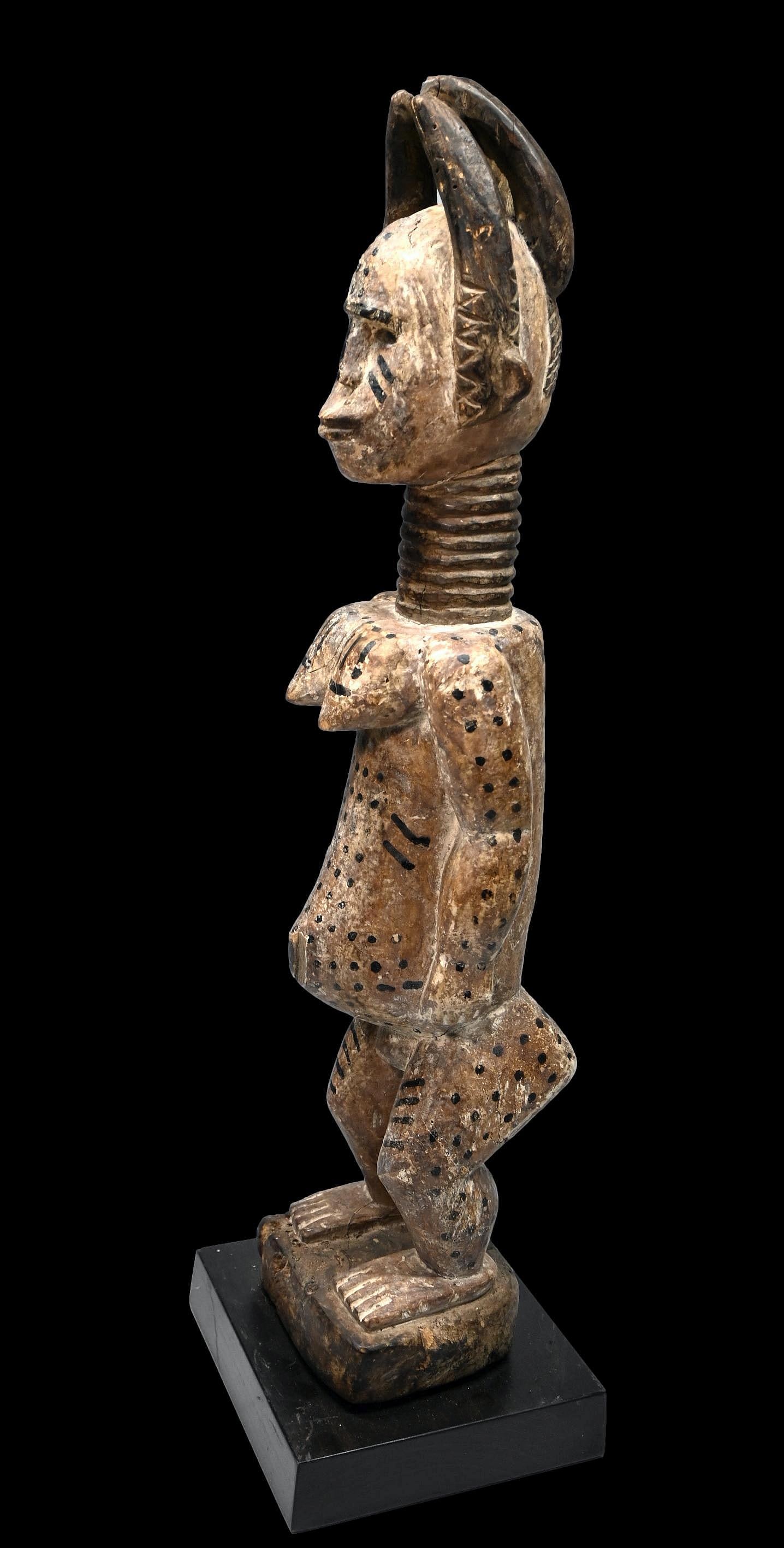Bold Akan Female Sculpture Ex Blum Collection: A carved wood and painted female shrine effigy with highly stylized coiffure, painted white skin with kaolin pigments, accented with linear and spot designs as well as a ribbed neck and overall styliz