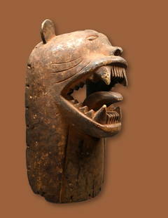 A Luba Feline Mask Ex Barthels Collection: A unusual carved wooden with feline or zoomorphic facial features, aggressive form and overall weathered surface. Luba ethnic group, Congo, central Africa. The mask measures 14.5 x 8 inches. A metal