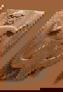 A Tana Toraja Granary Door: A weathered wooden door with an ancestor figure carved in relief shown atop a Buffalo effigy. This antique example was carved from nangka wood (jackfruit) with an aged and weathered patina. Buffalo