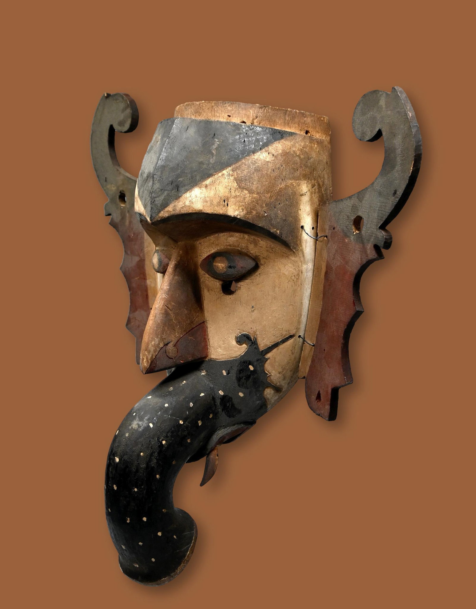 A Rare Dayak Hudoq Ceremonial Mask: A carved wood and painted mask with stylized elephant like trunk and attached ears, inset wooden teeth and tusks. Dayak peoples, Borneo / Kalimantan, , Indonesia. The mask measures 18 x 15 inches. The