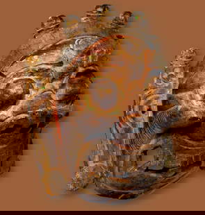 Mahakala Demon Mask from Tibet: A large aggressive carved wooden ceremonial mask featuring a demon like face and crown of human skulls, large fangs and wide nostrils, long ears. Mahakala is a fierce manifestation of the Hindu god