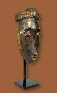 A Fine Old Baule Mask Ex Fiterman Collection: A carved wood and painted red dance mask with a highly stylized face and remains of wooden collar, now decayed and eroded away. The Long classic face accented with reddish organic / mineral pigments