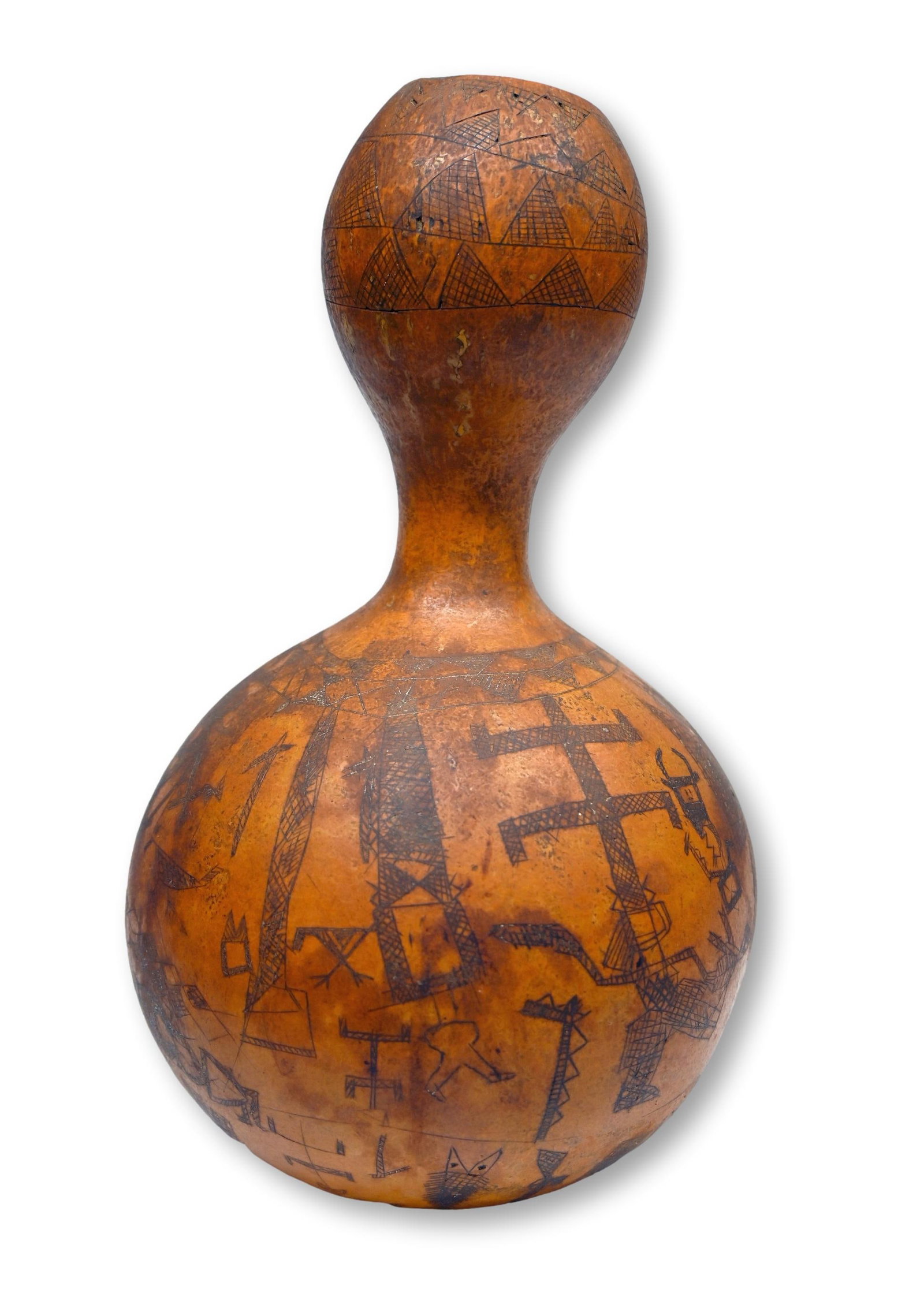 A Decorated Old Dogon Gourd: A well handled old vegetable gourd incised with various linear designs of Dogon traditional life. This is an antique to vintage example. Dogon peoples, Mali, Africa. The sculpture measures 12 inches t