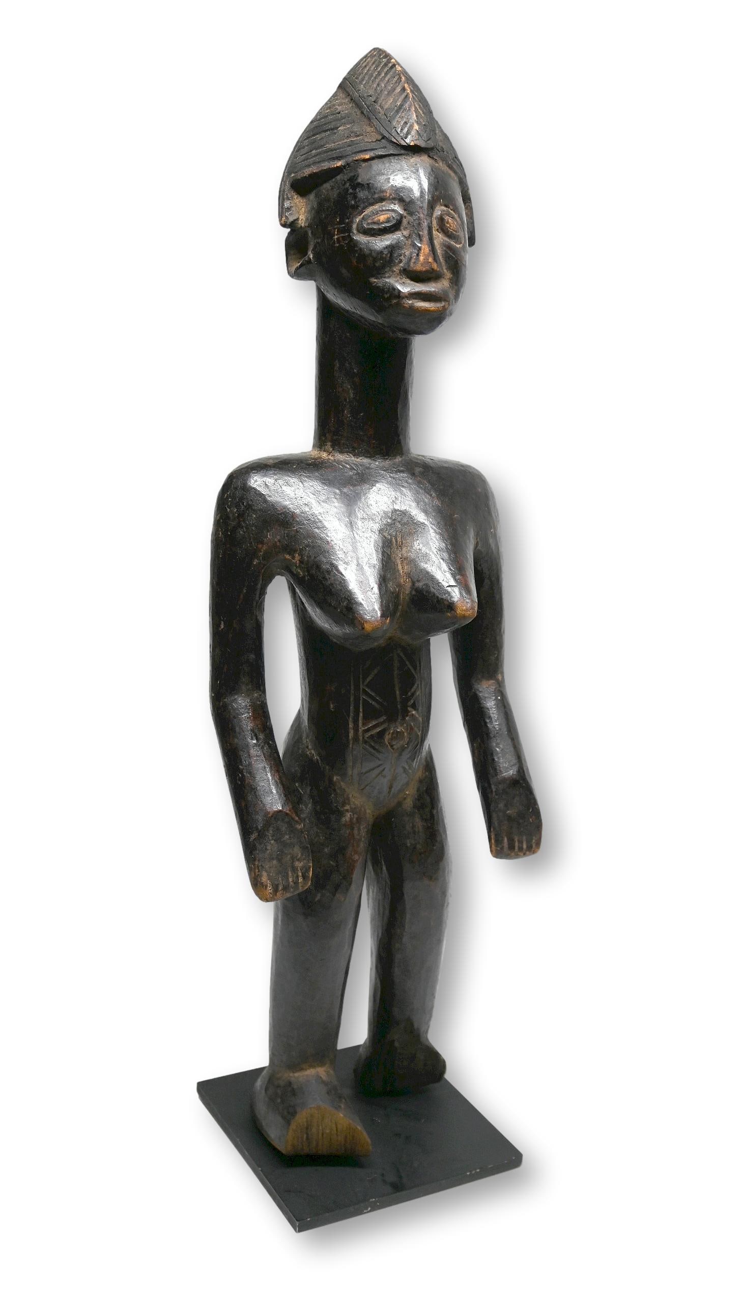 A Senufo Female Sculpture Ex Banks Collection: A finely carved female effigy with classic facial features, carved coiffure in traditional style and a deep well handled surface patina. Senufo peoples, Ivory Coast / Mali, West Africa. The sculpture 