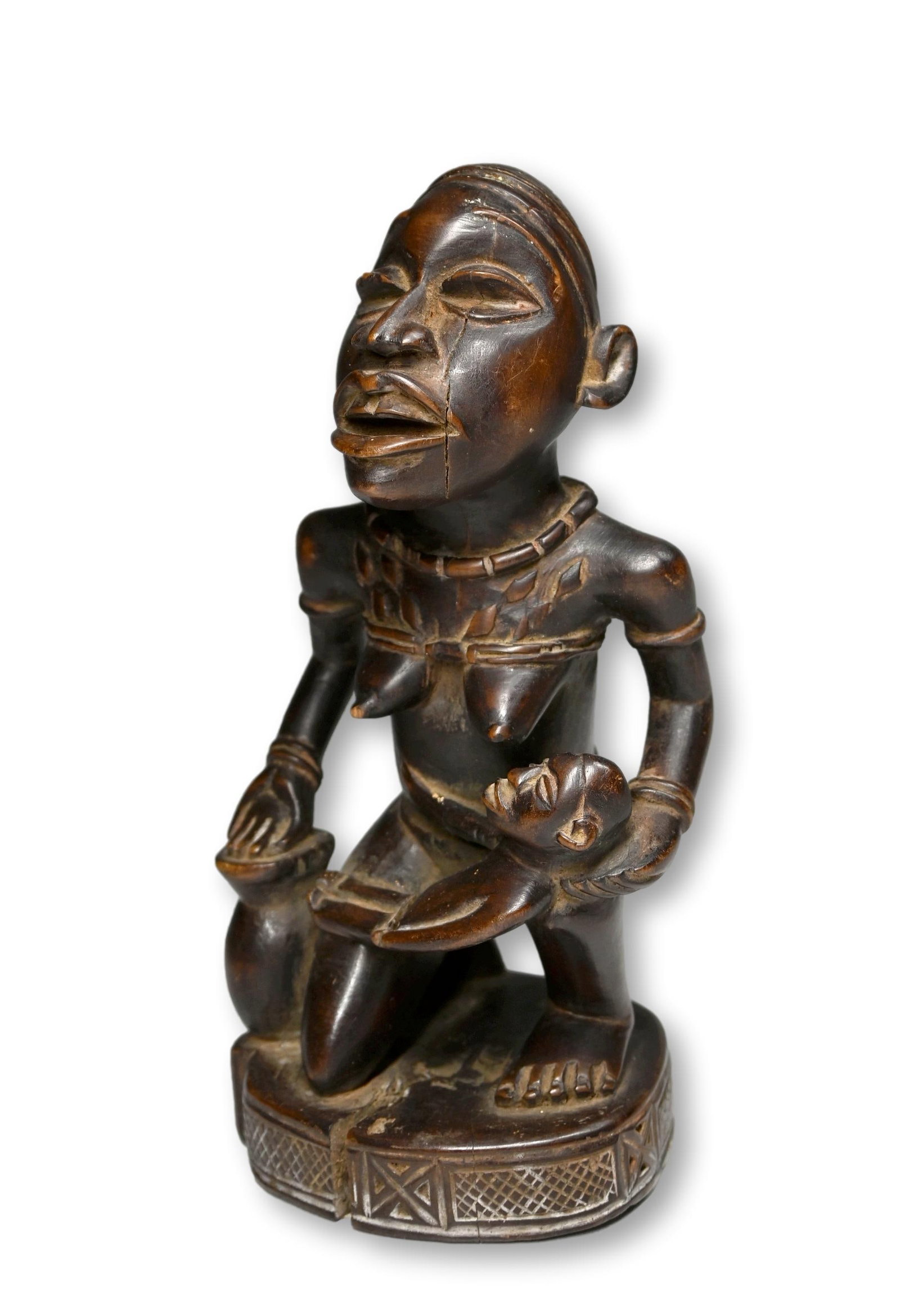 A Bakongo Maternity Sculpture: Carved wooden sculpture of a female with child, finely carved with some raised and incised designs. Bakongo peoples, DRC/ Congo, Africa. The sculpture measures 7.5 inches tall. Provenance: Ex Dr Gilbe