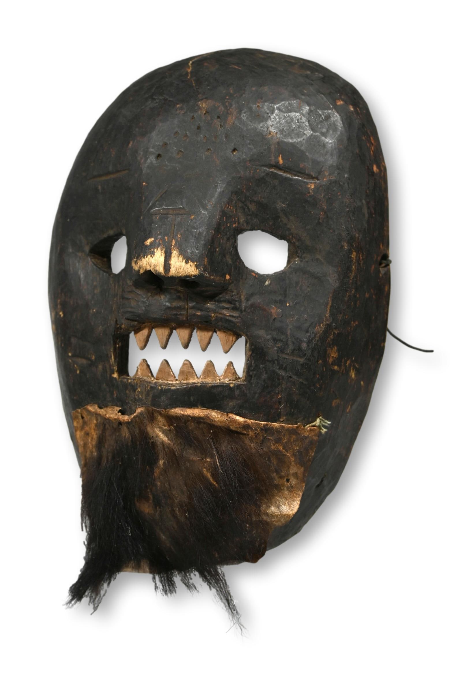 A Haya Mask Ex Irwin Hersey: This is a rare old Haya or Ziba peoples Mask from Tanzania, East Africa. The mask is carved wood with archaic features and a fierce expression with bared and filed teeth. The mask has an old patch of 