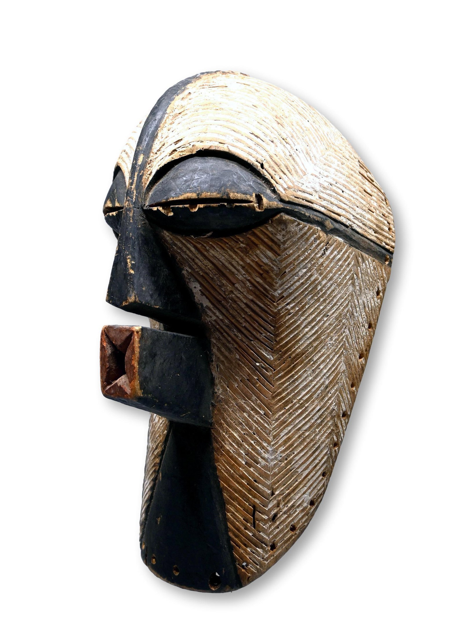 A Songye Kifwebe Female Ceremonial Mask: A carved wooden dance mask in classic form for a female mask with incised linear designs and accented with black and white pigments. Songye peoples, DRC/ Congo, central Africa. The mask measures 17 x 