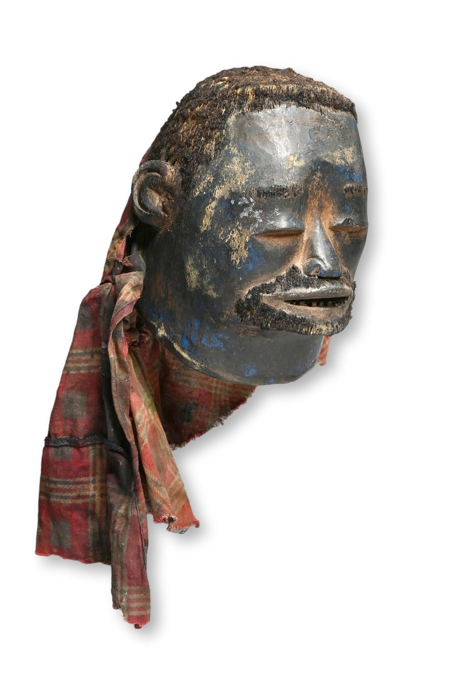A Makonde Lipico Initiation Mask: A finely carved old wooden ceremonial helmet mask with classic facial features, heavy lidded male, inset wooden teeth, inserted human hair with blue painted surface and signs of field use over many ye
