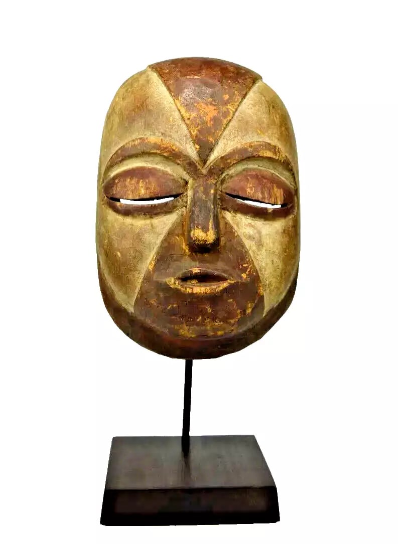 A Galoa African Mask Ex Banks: A carved wooden mask with a serene peaceful face and a well handled surface patina. Traditionally "okukwe" masks’ would perform during rite of passage ceremonies, such as births, initiation rituals,