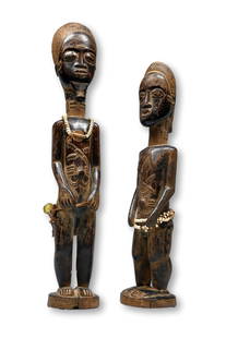 A Fine Pair of Baule Figures Ex Gallery K 1973: A very finely carved mated pair of Male and female ancestors sculptures in classic form with raised scar designs on the neck, back and torso. Adorned with glass beads. The male figure measures 14.5 an