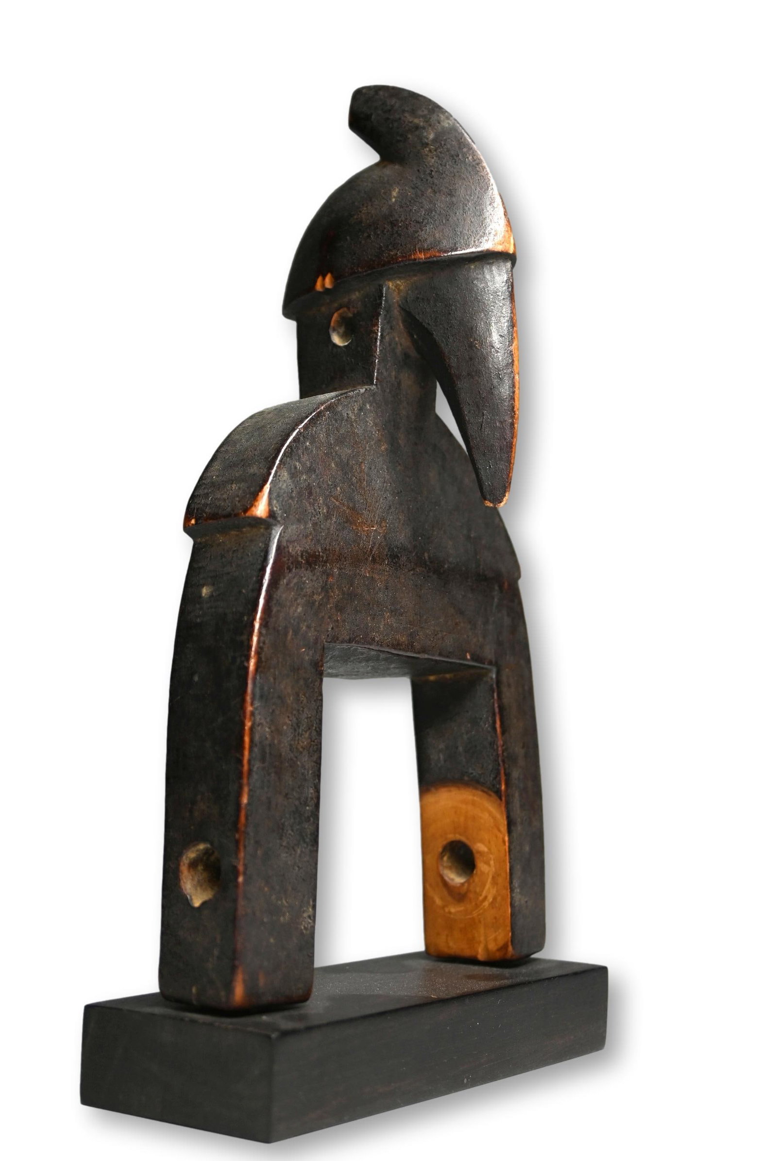 A Senufo Avian Pulley Ex Steinhacker Gallery 1979: A carved wooden heddle weaving pulley with a classic hornbill style finial, with signs of use and wear. Senufo peoples, Ivory Coast, West Africa. The Pulley measures 9 inches on a custom display stand