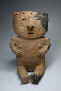 A Quimbaya Seated Figure Ex Cohen Collection: An ancient terracotta sculpture of a person in a seated pose. It is primarily made of fired clay and was produced by people living in the middle Cauca River Valley and parts of the Central Cordillera