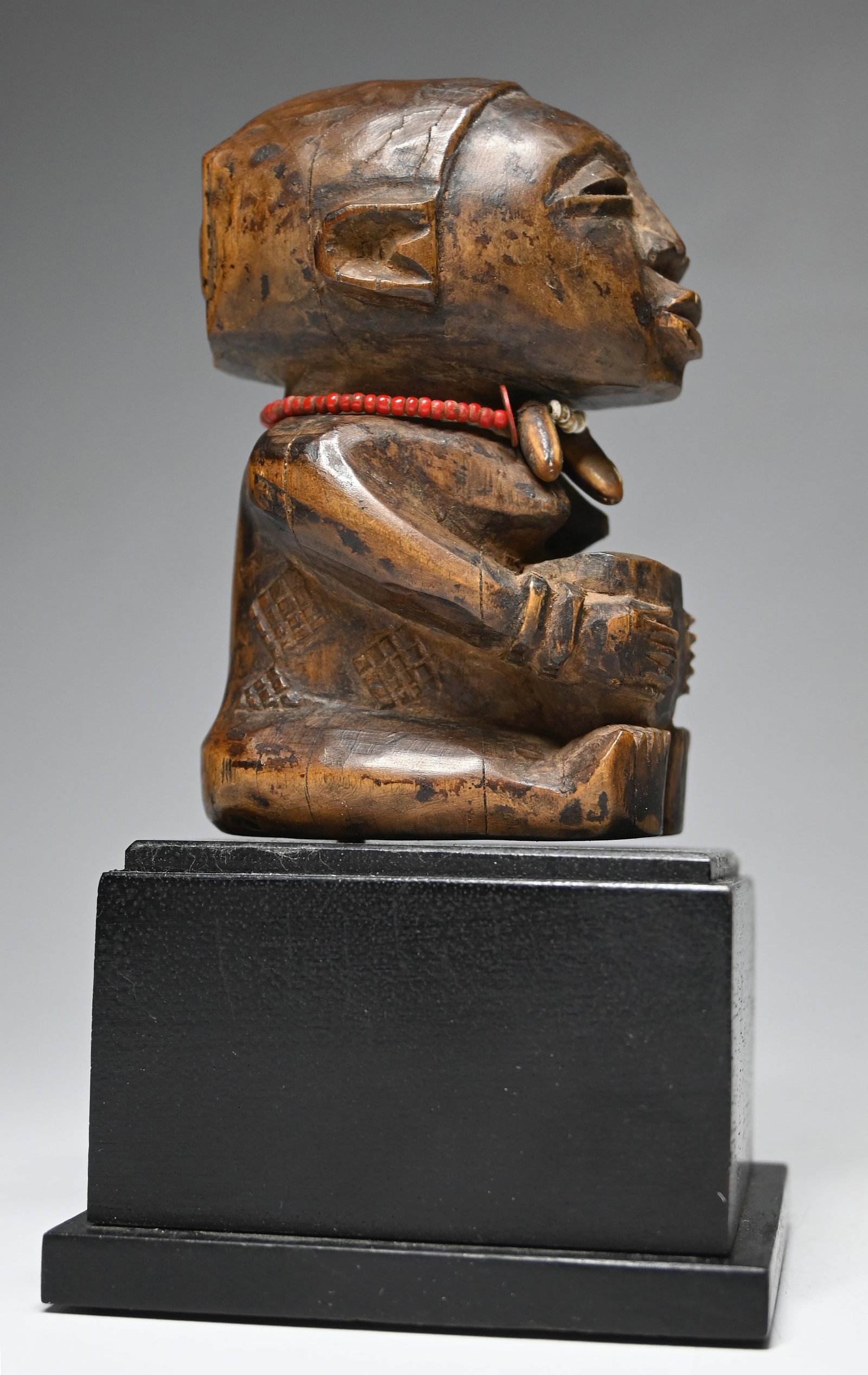A Luba Bowl Bearer Sculpture Ex Sam Hilu: A diminutive carved wooden female Mboko or bowl bearer sculpture adorned with glass beads and seeds. The sculpture itself measures 4.25 inches tall, 6.5 inches tall on professional custom base. Proven