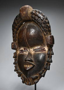 A Dan Bassa African mask: A beautiful carved wooden mask with inset teeth and highly stylized coiffure and collar, all carved from a single piece of wood. The mask measures 16 x 9 inches. Dan Bassa Ethnic group, Liberia,