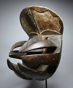A Bete Spider mask: A Carved wooden mask with metal tacks and long open work appendages that resemble a spiders legs. Bete peoples, Dan Complex of Tribes, Liberia, West Africa. The mask measures 13.5 x 9 inches. A