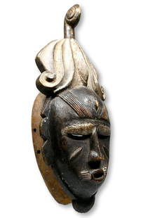 A Ligbe African mask: A carved wooden dance mask with a wonderful elaborate carved coiffure, raised linear designs and kaolin clay pigments. Such a mask would have been used by the Do association of the West African Ligbi