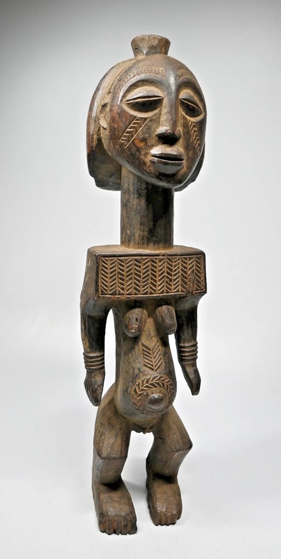 A Stylized Hemba Female Sculpture: This is a carved wooden commemorative sculpture of a female important ancestor from the Hemba peoples, of the DRC/ Congo, central Africa. This sculpture was carved from a very heavy dense wood with si