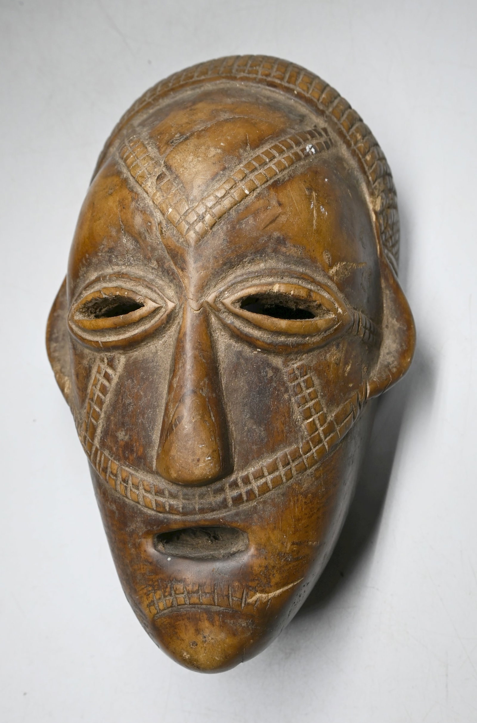 A Tabwa maskette: A small yet very interesting carved wooden mask with raised scar designs and very well handled and worn surface. Tabwa peoples, DRC/ Congo, Africa. The mask measures 8.5 x 4.5 inches.