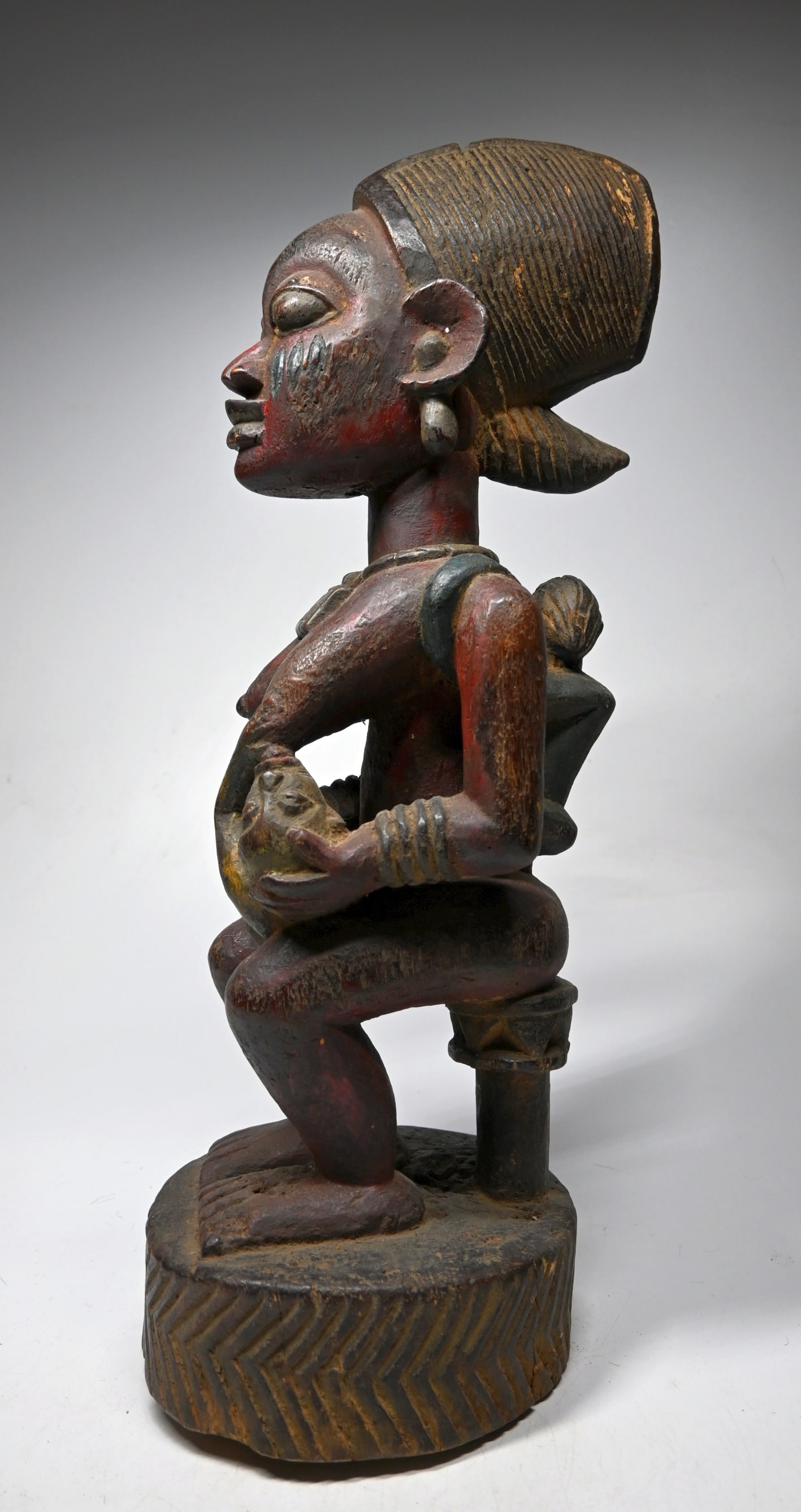 A Yoruba maternity Sculpture: A Tall carved wooden mother and children sculpture with polychromed paints. Yoruba peoples, Nigeria, West Africa. The sculpture measures 22 inches tall.
