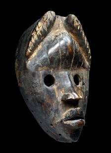 A Dan Mask: A carved wooden ceremonial mask with openwork eyes, stylized coiffure and a very well weathered and worn surface, various sized hand drilled attachment holes. Dan peoples, possibly Wobe or Toura subgr