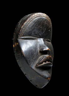 A Fine Dan African Mask: A Classic carved wooden ceremonial mask with well handled and worn surface, worn edges and attachment holes, inset metal teeth and incised linear designs on the forehead. Dan Peoples, Liberia & Ivory