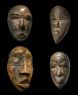 A Lot of Four Dan Passport Masks: A group pf four carved wooden miniature masks, one with rein and shells embedded into the back of the mask, all appear to have a well weathered and worn surface. Dan peoples, Ivory Coast, West Africa.