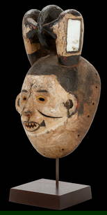 Igbo Ceremonial Dance Mask Ex Berman Collection: A carved wooden dance mask with tall superstructure representing stylized hair, including mirrors and painted designs. The mask was painted white with some mineral pigments, open work eyes and scars o