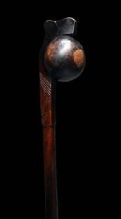 A Finely Crafted Zulu Club: A fine carved club or knobkerrie of a dark hardwood, with a pleasing two-toned wood, off set solid spherical head and incised linear designs. Such weapons were traditionally used for throwing at anima