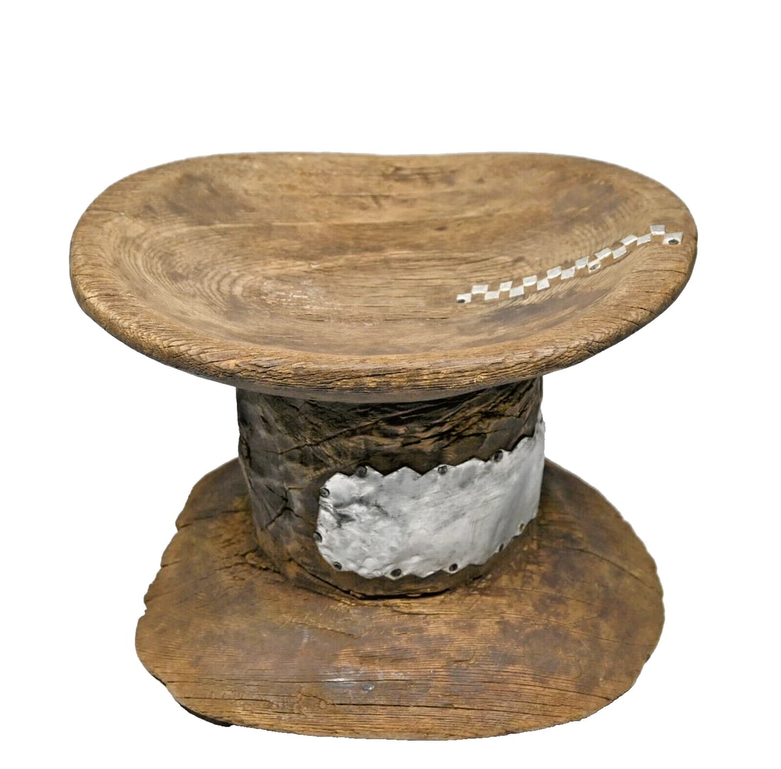 Old Turkana Stool with Tribal Repairs: A carved wooden stool with a wonderful style and form, well weathered and old tribal repair using hammered aluminum.~ what remains is quite beautiful. The stool measures 10.5 inches wide x 9.5 inches 