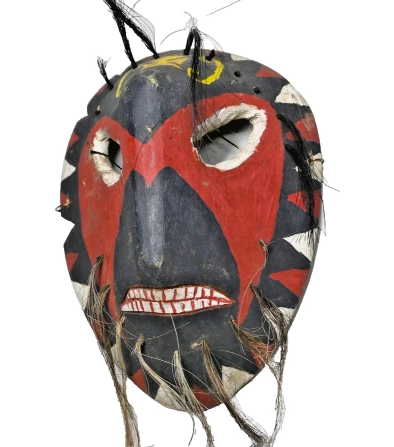 A Yaqui Indian Pascola mask: A carved wooden festival mask with red, black and white painted designs as well as long hair attachments from the forehead and chin. The Yaqui Indians, who have lived in the Mexican state of Sonora fo