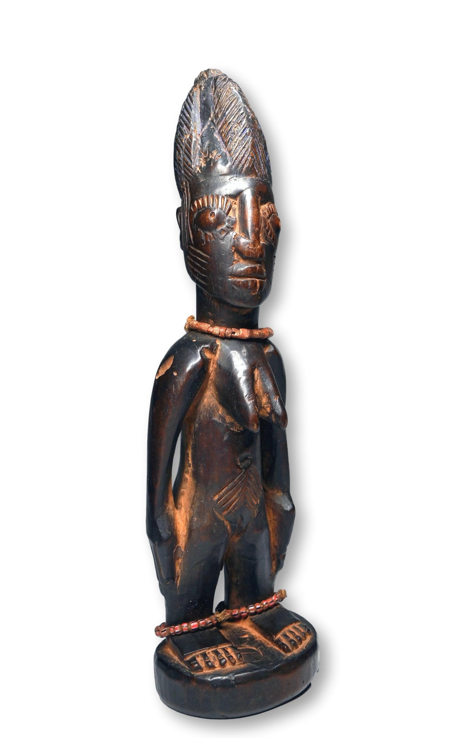 A Female Ibeji Twin Sculpture with Documentation: A finely carved wooden female twin sculpture with facial scars, tall coiffure dyed blue and a well handled surface patina. Ibeji Twin sculptures are created by the Yoruba peoples of Nigeria , West Afr