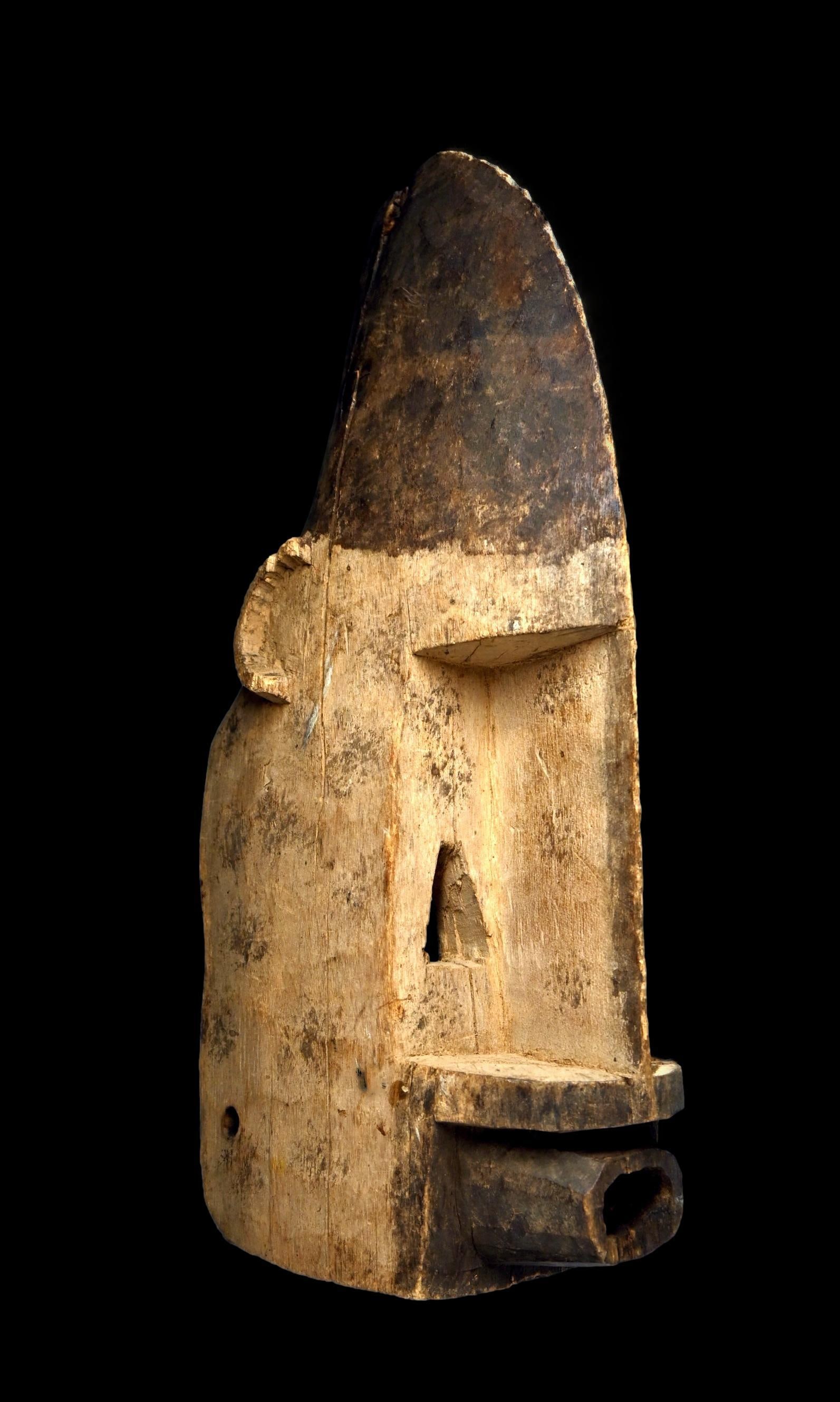 A Dogon Ceremonial Mask: A carved wooden dance mask with contrasting black and white pigments and a wonderful highly stylized conical form. The mask overall shows handling and wear. Dogon peoples, Mali, West Africa. The mask