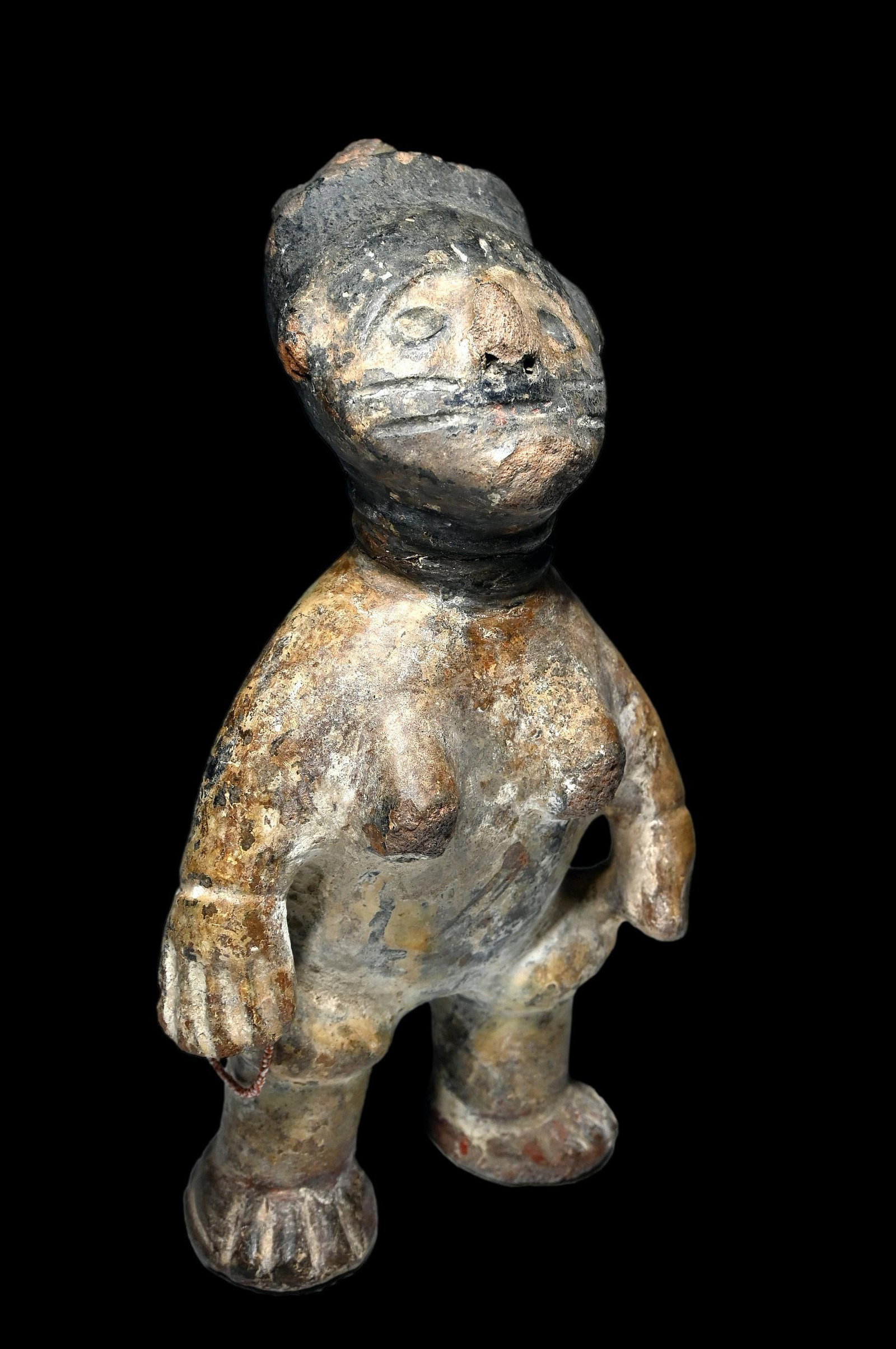 Akan Memorial Terracotta Sculpture: A terracotta clay effigy of a female with stylized form, incised facial scars, ringed neck and adorned with a small strand of beads. Such sculptures are often created to memorialize passed ancestors. 