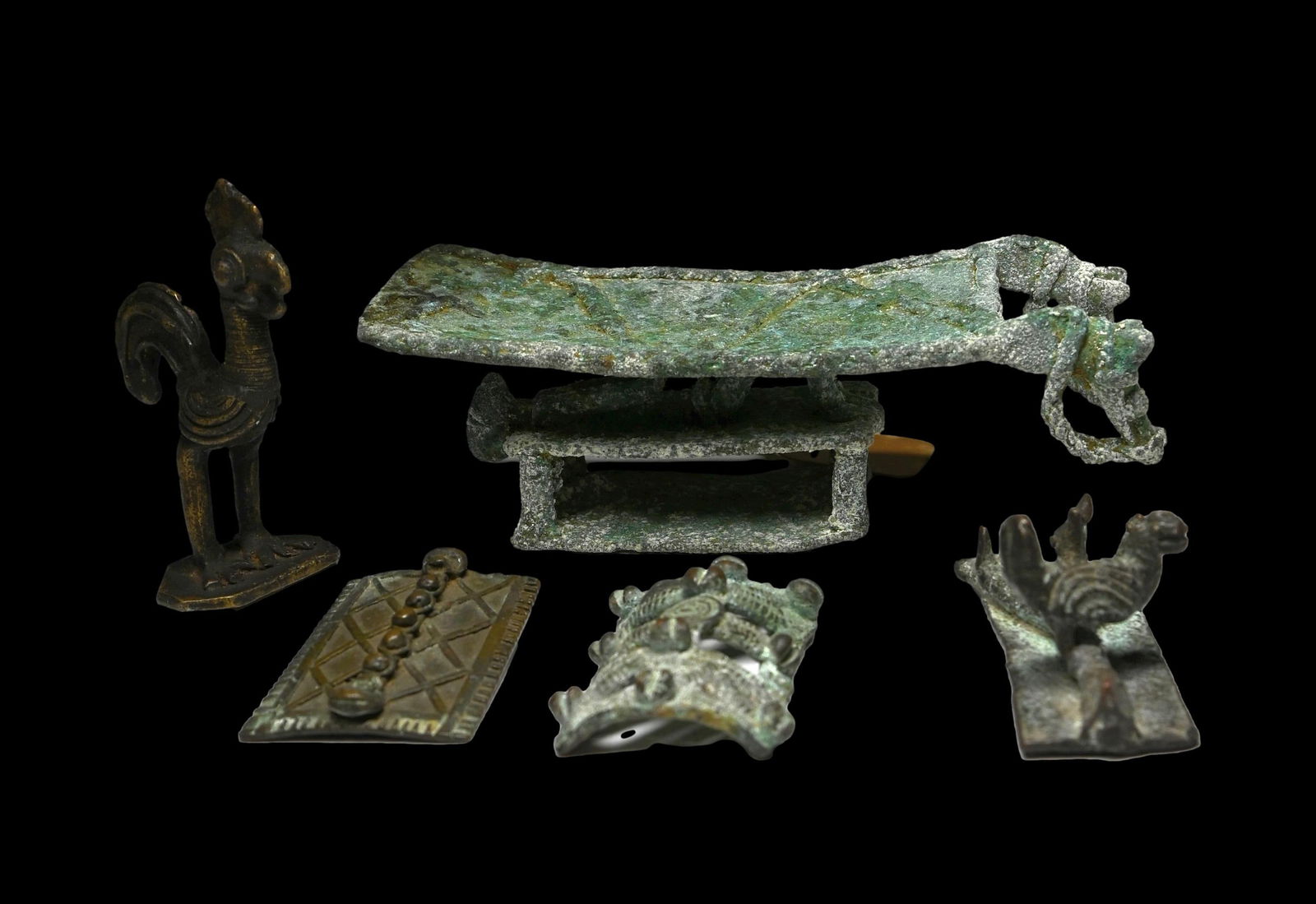 A Lot of Ashanti Bronzes: This lot contains 5 African / Ashanti bronzes from Ghana. 4 Gold weights, with a Rooster, and a small rooster and plant, and two geometric forms, as well as a larger stylized bench with anthropomorphi
