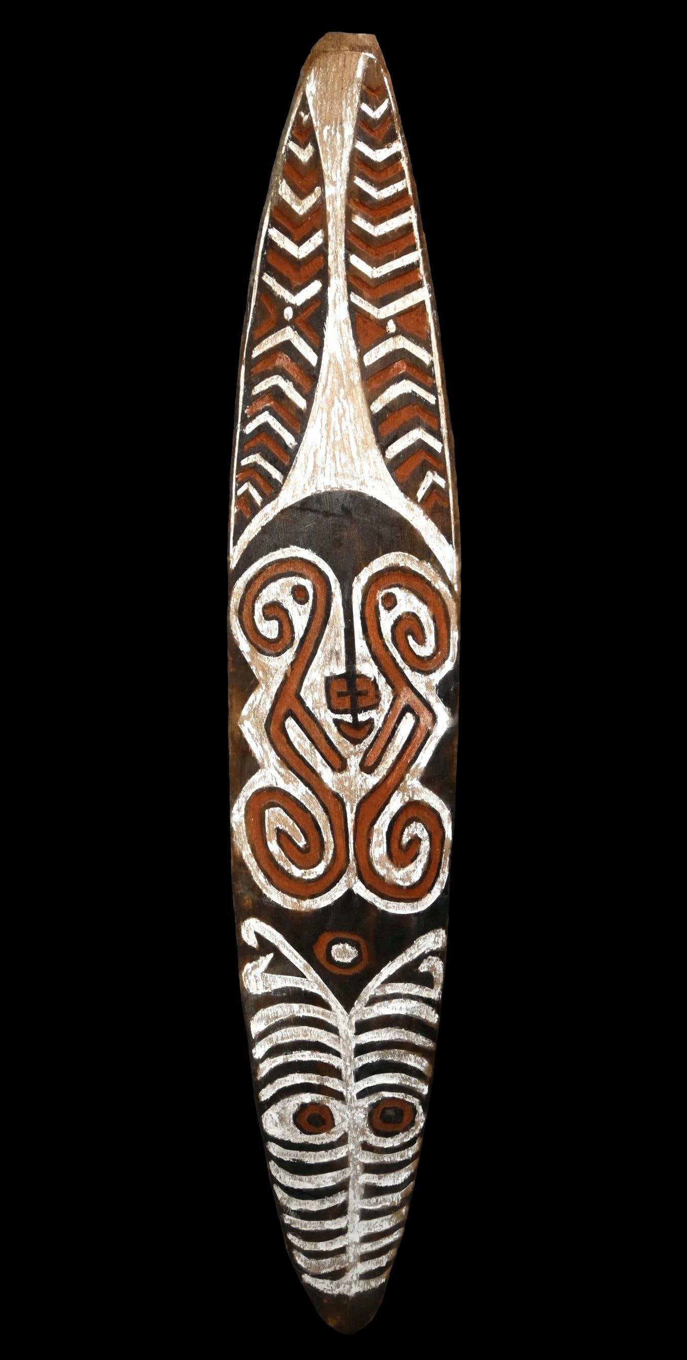 A Gope Board from Papua New Guinea: A stylized Kikori area spirit board (Gope), Gulf province Papua New Guinea. (C. 20th Century).This carved wooden board of classical style for the region, with central stylized face surrounded by zigza