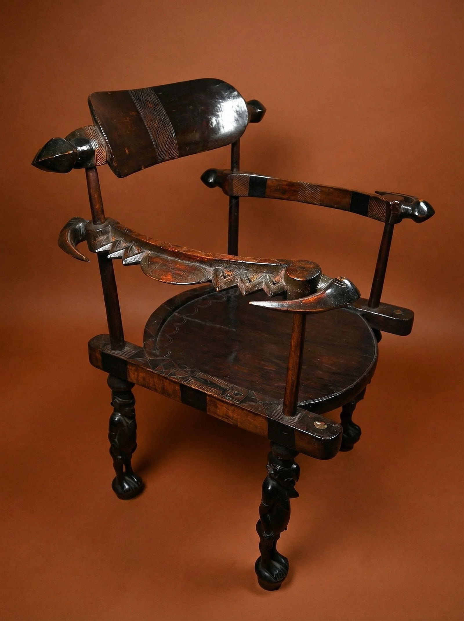 A Senufo Chair Ex Christies Auction: A finely carved wooden chair featuring avian and reptile images as well as two male and two female ancestors as supports on the legs , decorated with curved forms and linear designs, a beautiful examp
