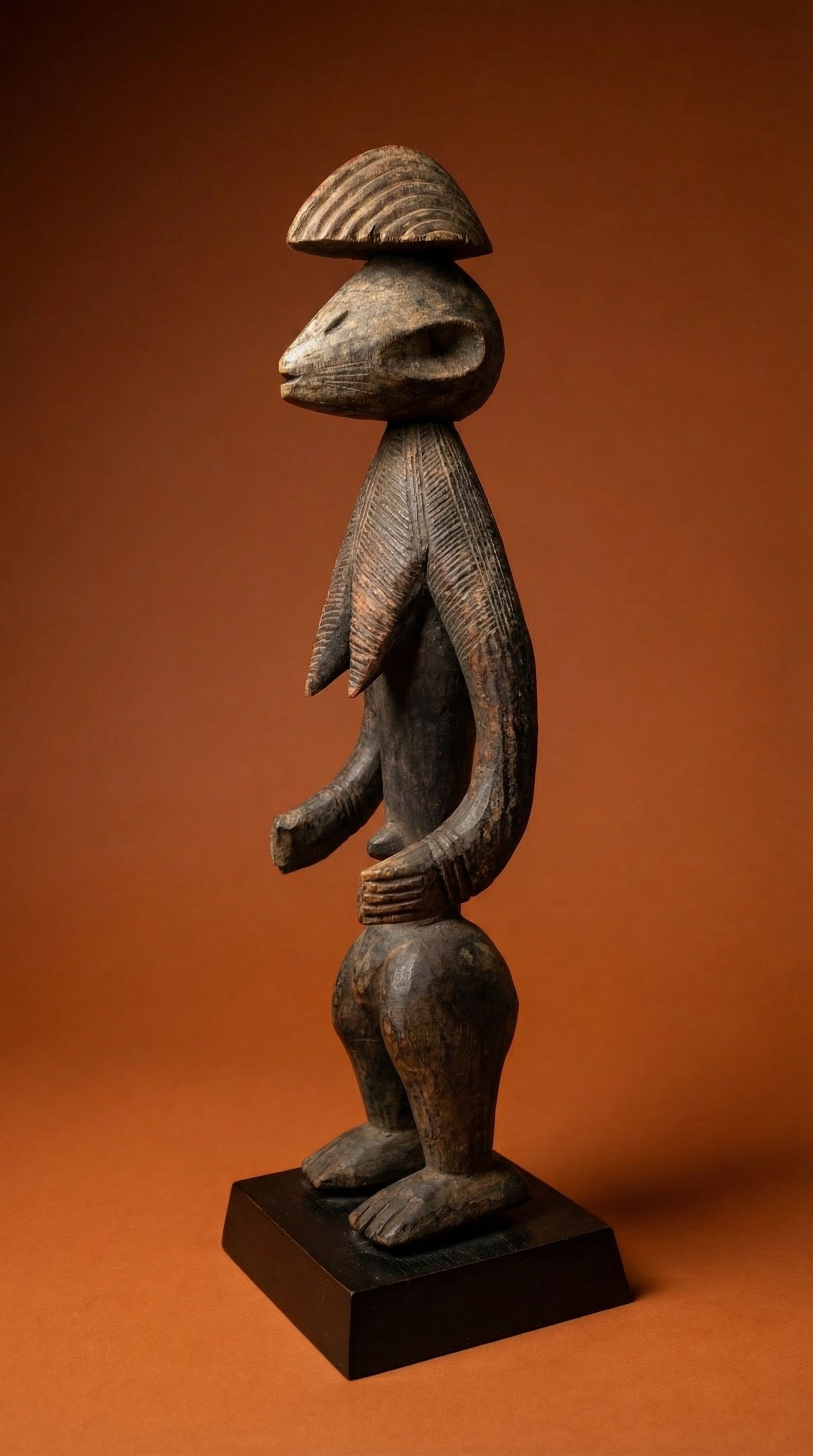 A Montol Sculpture: A highly stylized sculpture with exaggerated head and facial features, the coiffure, chest and arms covered in linear designs. The overall sculpture is wonderfully stylized in form. Montol peoples, Ni