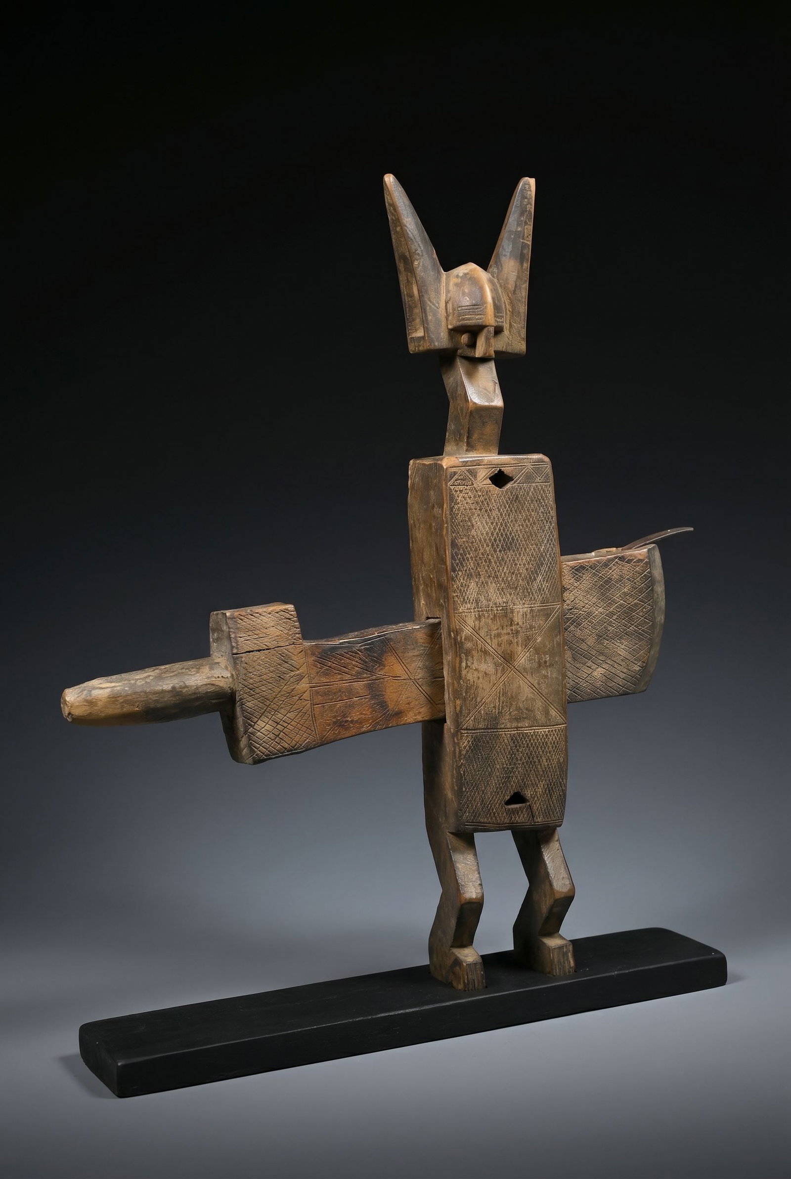 A Bamana Door Lock: A finely carved wooden door lock for a granary door or other featuring a classic anthropomorphic figure as the body of the lock and with tall stylized ears similar to a traditional Hyena mask. Incised