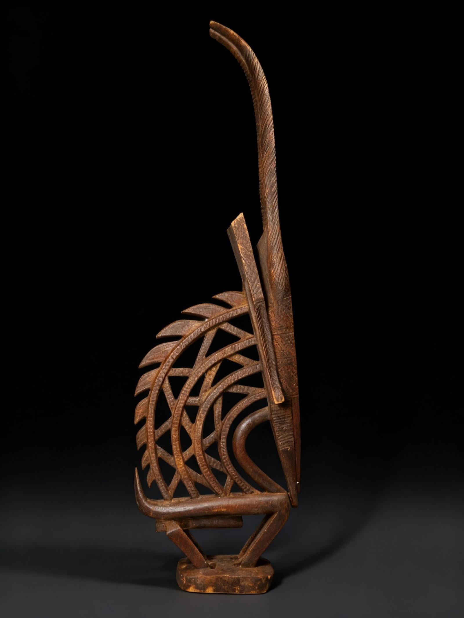 A Bamana Chiwara Antelope Ex Museum 1972: A Finely carved Chiwara antelope headdress in classic form with openwork design and incised details. This is a traditional wooden, antelope-shaped sculpture that represents a mythical being. Part huma