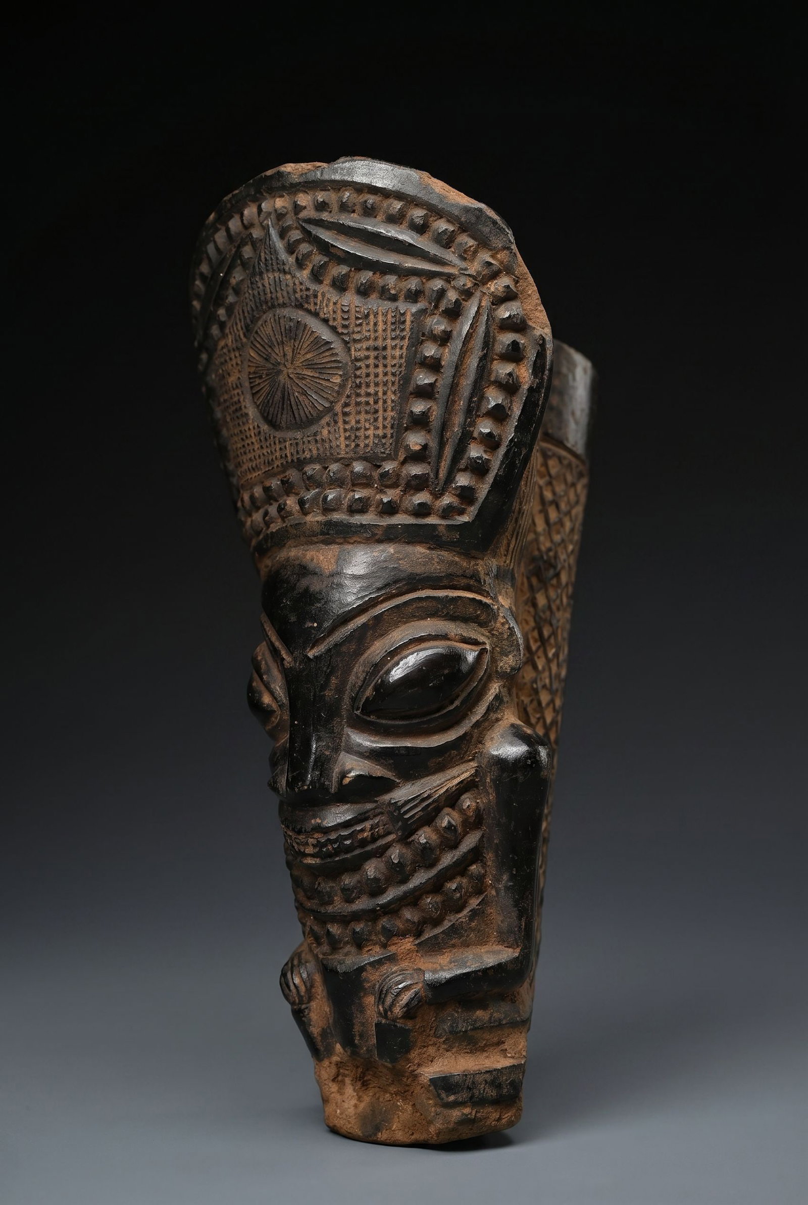 A Bamun Terracotta Pipe Bowl & Stem Ex Baltimore Museum 1972: A very finely crafted terracotta clay pipe bowl with a long wooden stem wrapped in silver metal. The Pipe overall shows signs of field use over many years. The Bowl measures 6.25 inches tall and the s