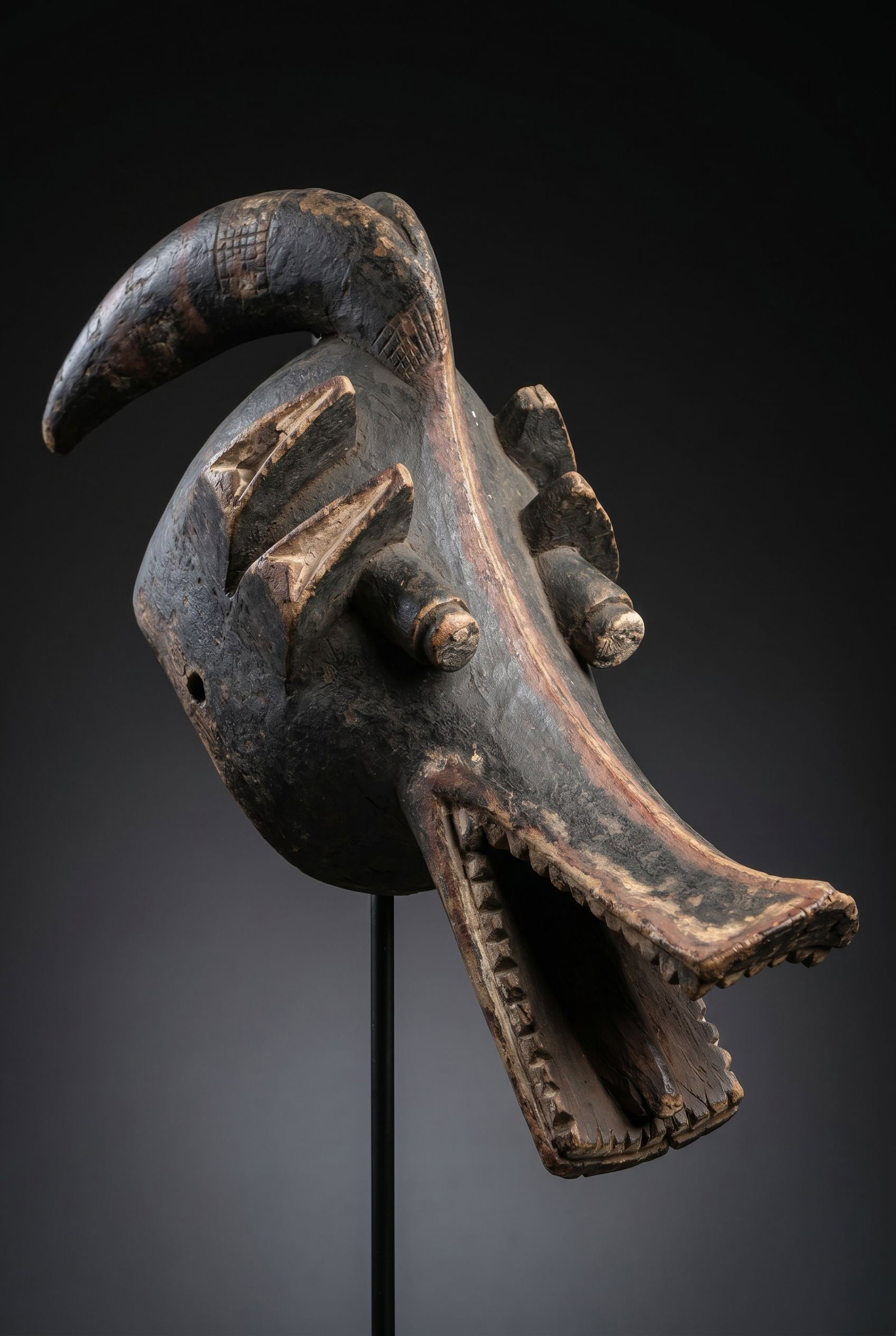 A Mambila Suaga Mask: A carved wooden zoomorphic mask that is said to be a blend of canine and crow , perhaps antelope as well. The Suaga headdresses are worn among the Mambila of Cameroon and Nigeria during agricultural a