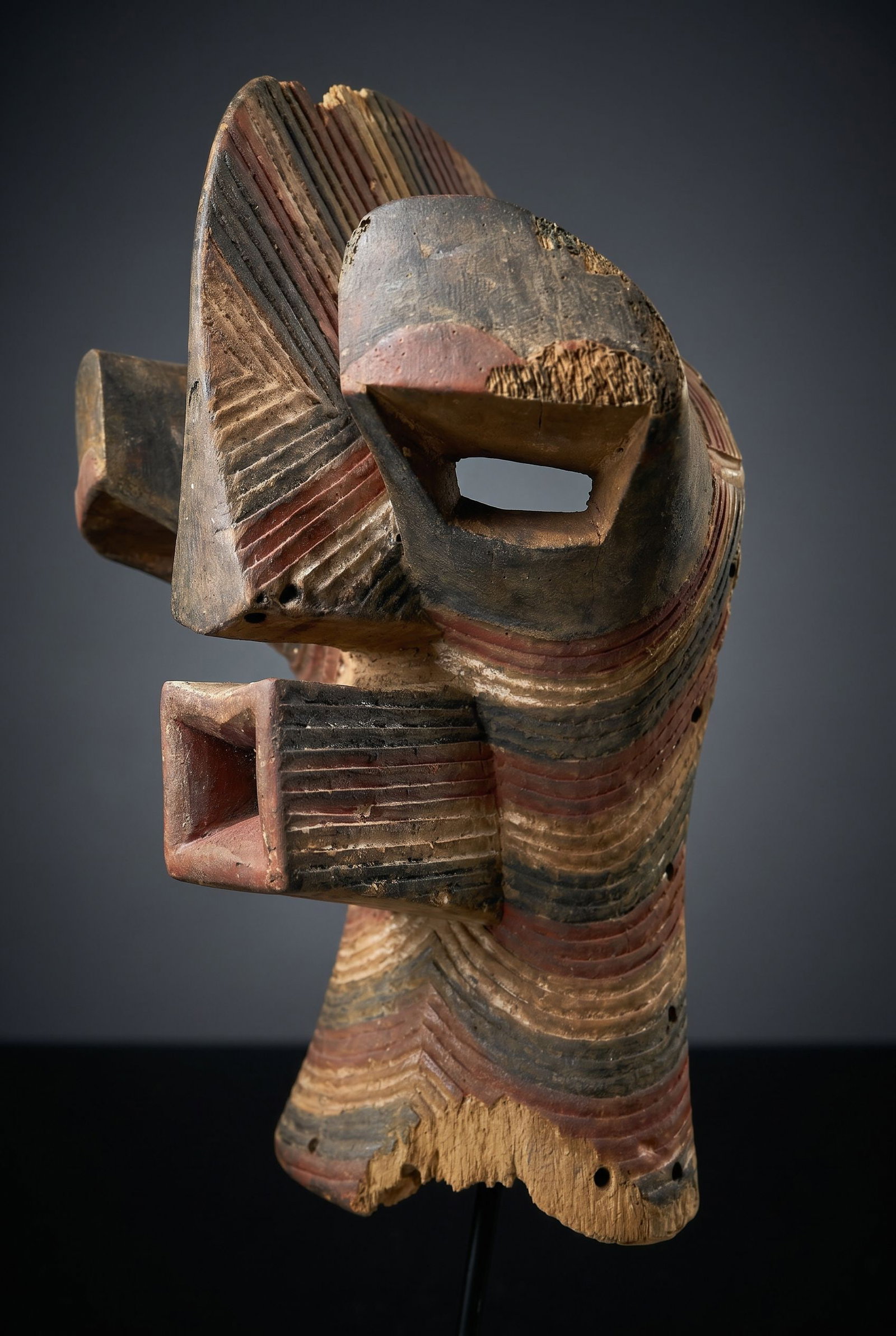 A Songye Kifwebe Male mask: A carved wood and highly stylized ceremonial Male mask decorated with incised linear designs and painted with various red, white and black pigments. Songye peoples, Kifwebe society, DRC/ Congo, centra