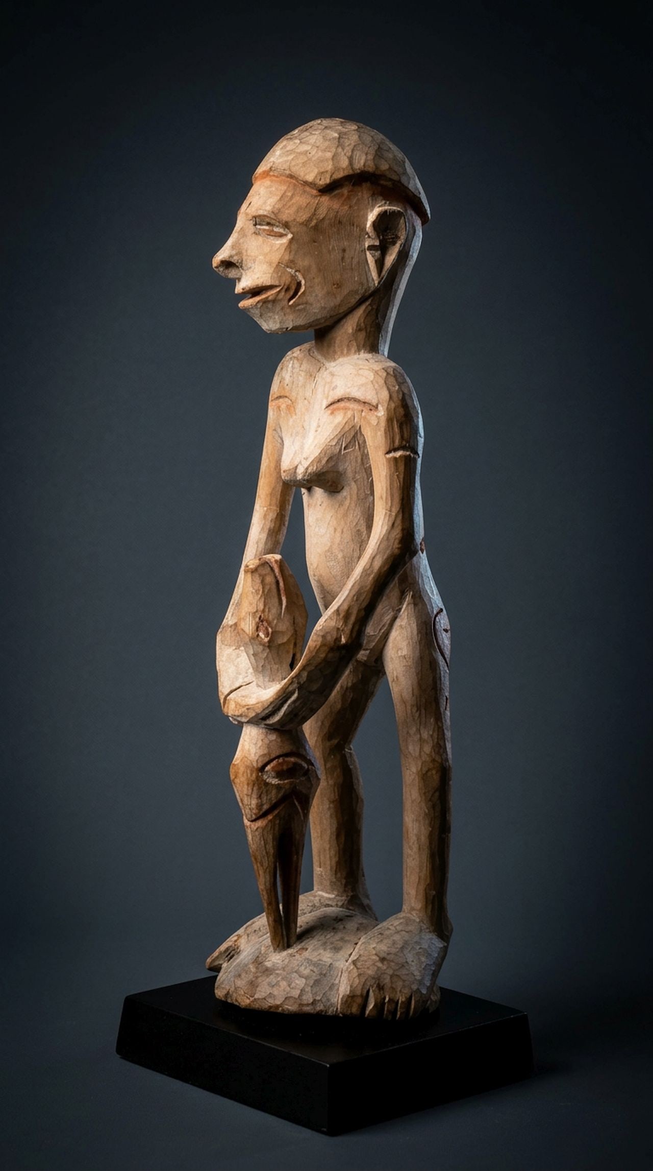Asmat Ancestor Sculpture Ex Stirner collection: A carved wooden female effigy shown holding a zoomorphic abstract figure, possibly reptile and avian heads, and painted white with kaolin clay pigments and orange or rust colored accents. Asmat people